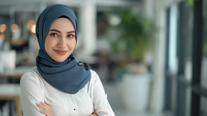 Foto auf Alu-Dibond A successful Muslim businesswoman in a hijab, portraying leadership and professional motivation, set against an office backdrop. © sderbane