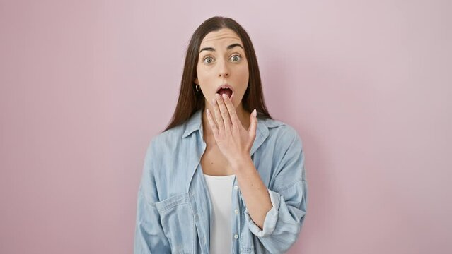 Young hispanic woman wearing casual clothes, astonished and scared, open-mouthed in amazement over isolated pink background! amazed, fearful female portrait!