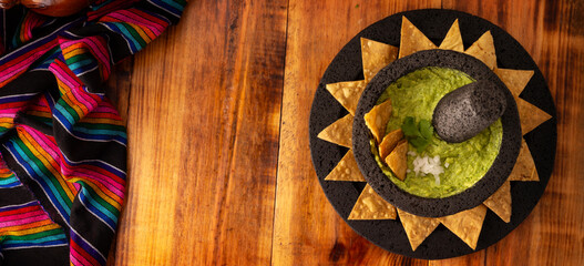 Guacamole. Avocado dip with tortilla chips also called Nachos served in a bowl made with volcanic...