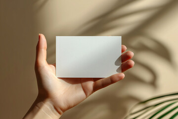 Naklejka premium Flat lay Handheld Wedding Invitation card against the dried plant and white flowers 