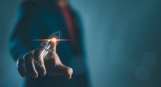Businessman touching on rocket launch with up arrow, investment growth, planning and starting corporate business start up aiming objective value development leadership and customer target group.