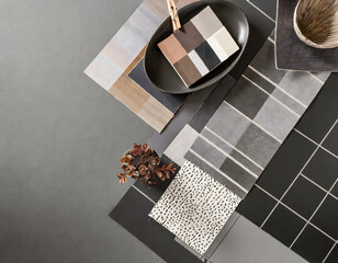 Elegant flat lay composition in grey and black color palette with textile and paint samples. Generative AI.