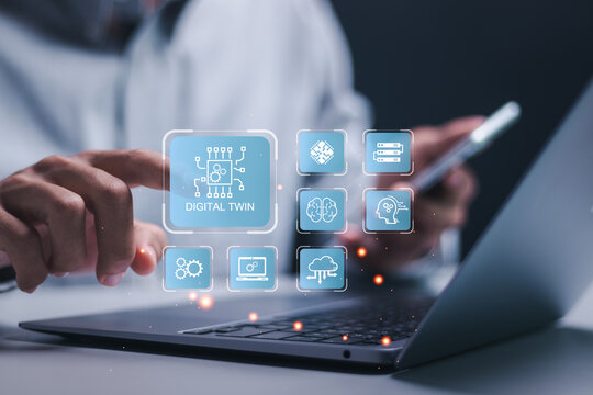 Digital twin business and industrial process modelling. Businessman use laptop with virtual icons of digital twin for innovation and optimisation by manufacturing automation technology. - Powered by Adobe