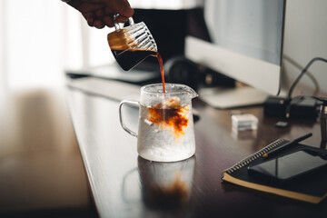 Iced coffee in a glass mug on the work desk