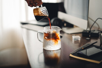Iced coffee in a glass mug on the work desk