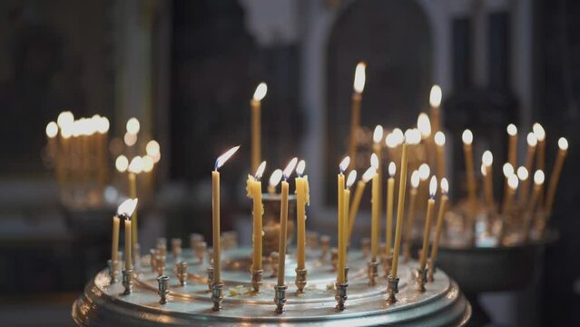 The theme of religion, faith, Christianity, God and the Orthodox Church. A close-up of much waxed candles are burning in a candlestick. Religious concept.