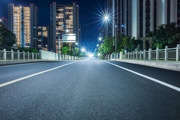 Fototapeta na wymiar New asphalt road and cityscape at night
