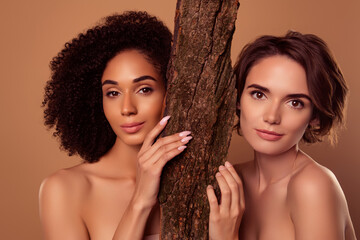 Photo of two attractive charming girls mystical magical dryads hide behind tree bark in woods over pastel background - obrazy, fototapety, plakaty