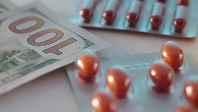 Money puts next to medicines and pills. Economic aspects of healthcare.