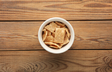 Bowl with salty snack cookies on wooden table