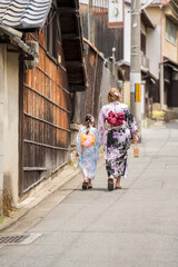 Japanese girl wearing traditional kimono Yukata walking on the street in Kyoto, Japan.