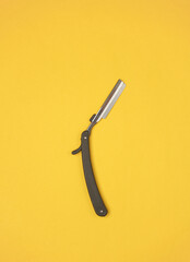 Obraz premium Straight razor on yellow background