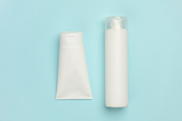 White bottles of cream on a blue background. Cosmetics