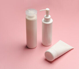 Cosmetics bottles on pink background