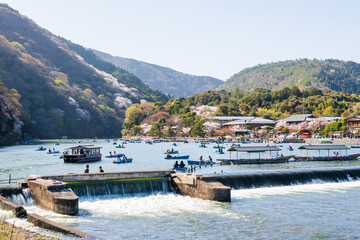 Kyoto, Japan - March 28 2023 : Cherry blossoms in Arashiyama district. Rental boats on Katsura...