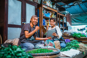 potrait happy vegetable sellers sitting with fist pump gesture