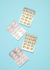 Blisters of tablets and pills on a blue background