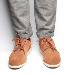 Male legs in suede shoes on a white background