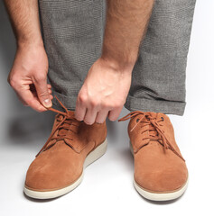 Male legs in suede shoes on a white background