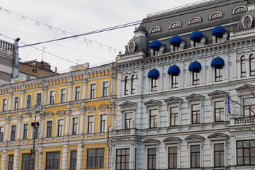 Obraz premium KYIV, UKRAINE - JANUARY 19, 2024: very beautiful architecture in the city center. historical buildings of different colors in different districts. gloomy weather and snowy city. people are walking