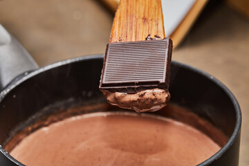 Chef Cooking Chocolate Mousse in Home Kitchen with Saucepan and Spoon
