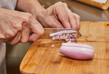 Slicing Fresh Shallots on Wooden Cutting Board with Kitchen Knife