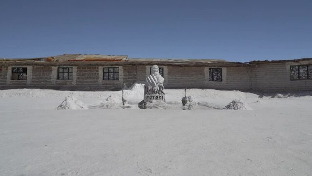 Salt statue of famous dakar monument in front of the salt hotel on the Salar de Uyuni flats, a popular travel destination in the high altitude of the Altiplano in the Andes of Bolivia.