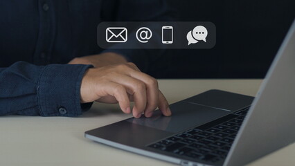 Customer support hotline Contact us people connection. Businessman using computer keyboard with the email, call phone, address, Chat message icons.