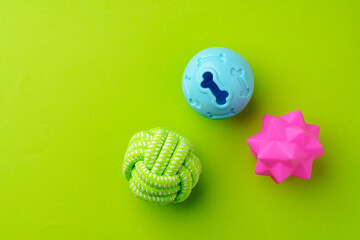 Colorful pet toys balls on green background