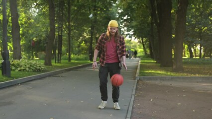 Young red-haired guy dunking a basketball in the park on a summer evening - Powered by Adobe