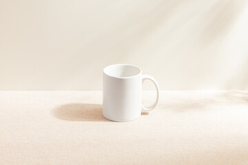 White mug isolated on wood background. Drinking water. White mug. Beverage. Fabric surface. Simplicity. Minimalist object. Space for text. Mockup. Ceramic. Cup of coffee. Morning time.