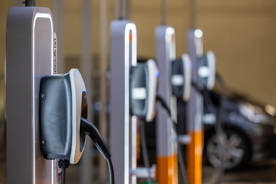 EV charging and electric car, Electric car charging station for charge EV battery, Plug for vehicle with electric engine, EV charger clean energy, Charging point at car parking lot.