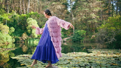 Magical princess posing lake covered water lilies. Forest nymph standing pond