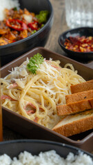 Fettuccine pasta served with cream sauce and bread.