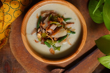 a bowl of sayur nangka muda on wooden background 