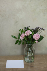 Bouquet of pink carnation flowers in a glass vase on the table