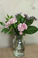 bouquet of pink carnations in a vase on a wooden table. copy space.