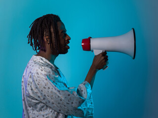 African American man dons traditional attire, passionately utilizing a megaphone against a striking...