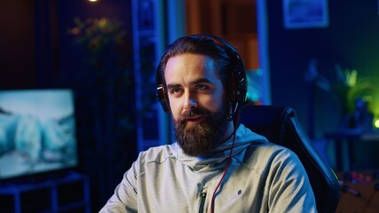 Streamer in studio playing videogames, streaming for online viewers, talking with them about upcoming esports competition. Pro gamer broadcasting gameplay in front of internet audience