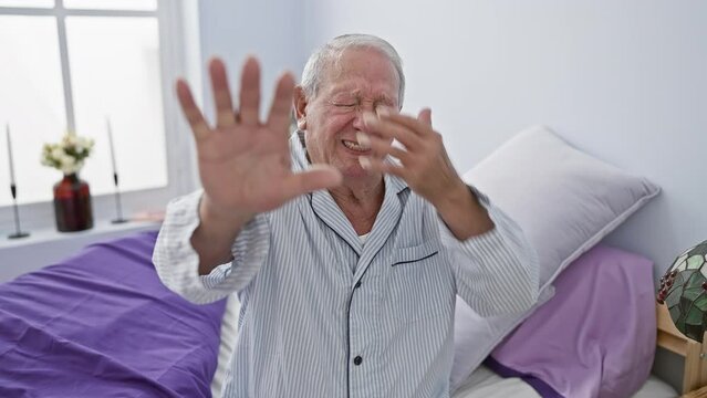 In a dim-lit bedroom, a downtrodden senior man wearing pyjamas covers his tear-filled eyes with shaking hands, gesturing stop in deep embarrassment and fear, radiating negative vibes.