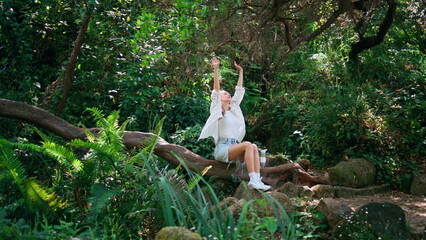 Relaxed girl resting on nature feeling peace harmony. Woman sitting tree trunk