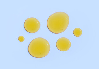 drops of serum essence on a light pastel blue background