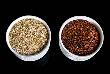 Red and white quinoa on the two white plates on the black background. Healthy food and nutrition concept. Safe, ecological, and healthy products