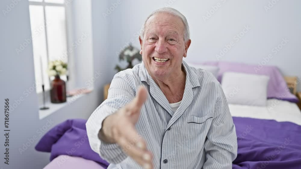 Wall mural Friendly senior man in pyjamas, smiling and offering a warm handshake from bed. a symbol of successful business welcoming gestures, right from his bedroom.