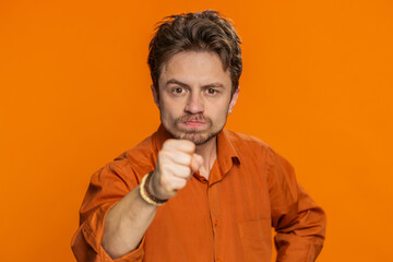 Quarrel. Displeased aggressive unhappy Caucasian man gesturing hands with irritation and displeasure, blaming scolding for failure, asking why this happened. Bearded guy isolated on orange background