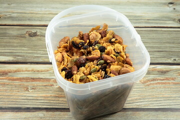 Pile of caramel cornflake mixed with baked cashew nut, almond, raisin and pumpkin seed in the...