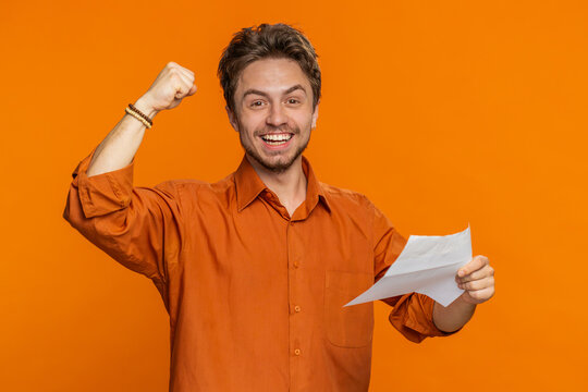 Bearded man open envelope take out letter reads it feel happy. Career growth advance promotion bank loan approve monetary award, long-awaited invitation great news. Handsome guy on orange background