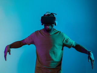 African American man dons VR glasses, engrossed in a virtual reality simulation, gesturing with...