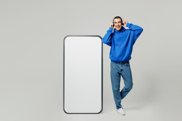 Full body young fun man he wear blue hoody casual clothes big huge blank screen mobile cell phone...