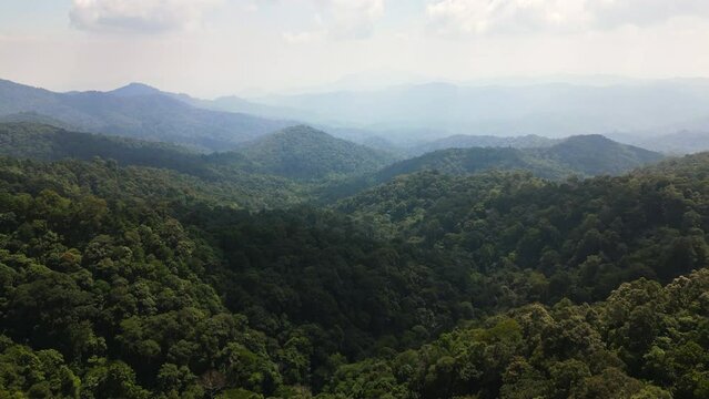 Aerial drone fly near Kew Fin viewpoint, Thailand. View of deep forest, mountains and hills in jungle. Cloudy weather.